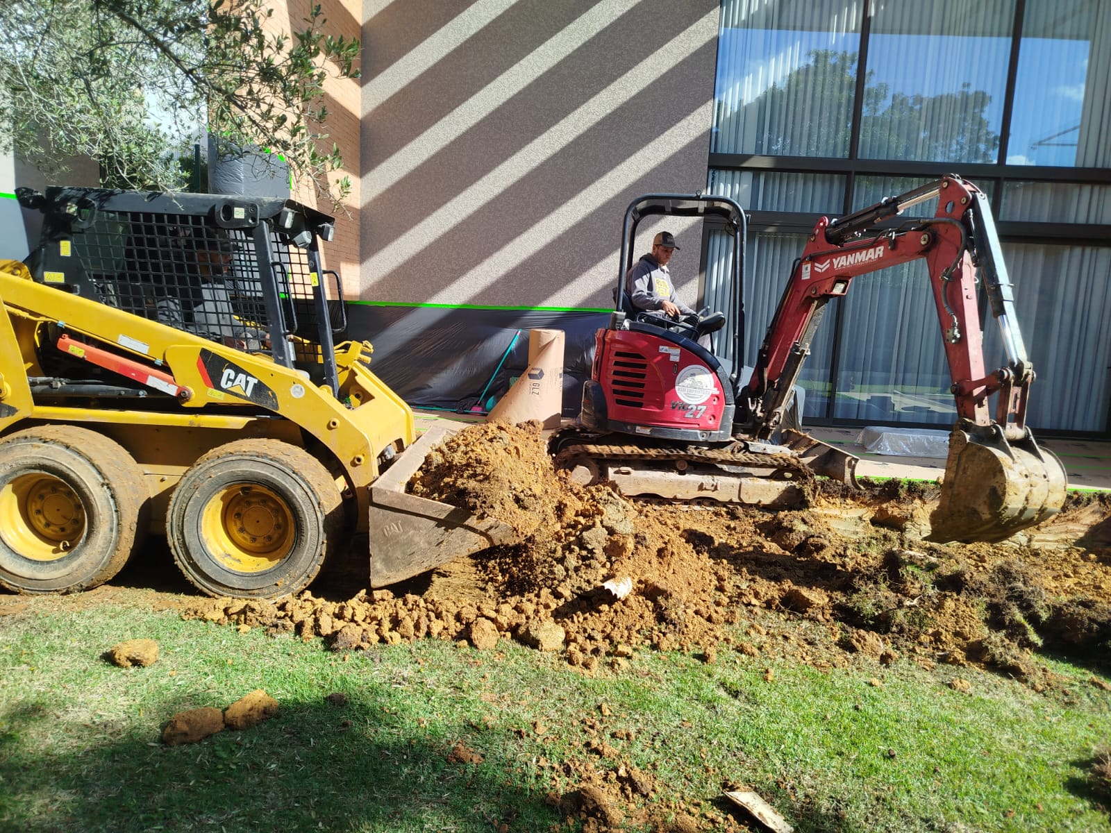 Mini carregadeira e mini escavadeira em obra residencial
